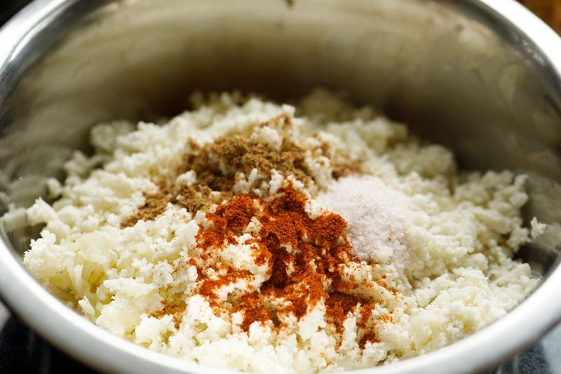 ground spices, grated paneer on the grated potatoes