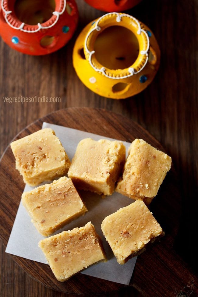 overhead shot of six cubes of easy mysore pak on a wood table